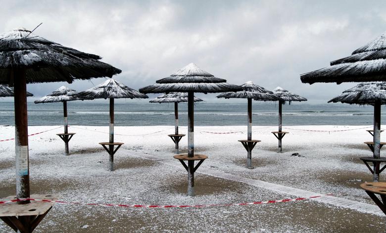 Những cây dù nằm bên bờ biển Artemida, Hy Lạp được tuyết 'tô điểm' thêm phần bắt mắt.