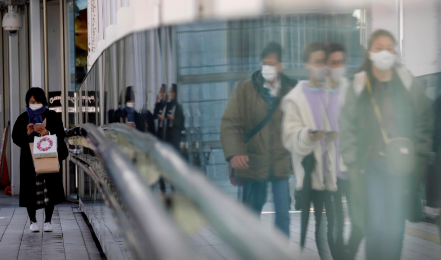 Những người đi bộ đeo khẩu trang bảo vệ trong bối cảnh bùng phát dịch bệnh do coronavirus (COVID-19), đi trên một con phố ở Tokyo, Nhật Bản, ngày 2 tháng 2 năm 2021. REUTERS / Kim Kyung-Hoon /