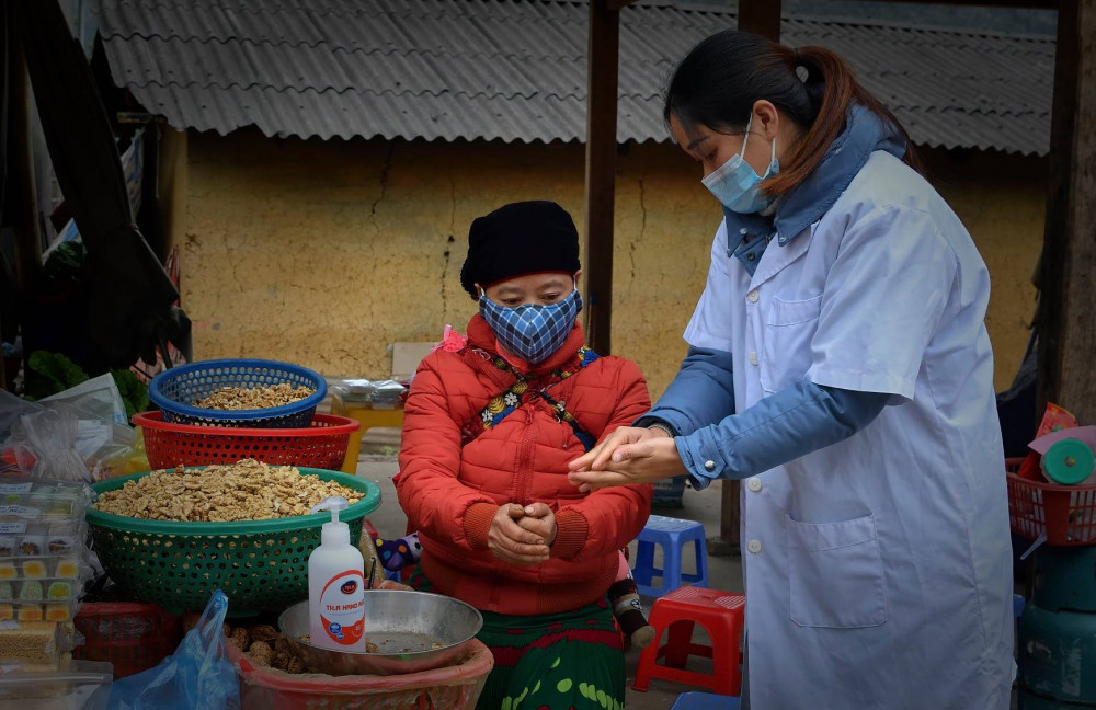 Hướng dẫn bà con tiểu thương rửa tay sát khuẩn tại chợ Sà Phìn.