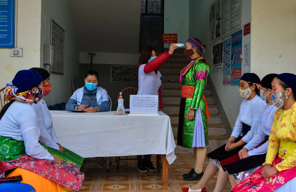 Kiểm tra thân nhiệt tại trạm y tế thị trấn Đồng Văn.