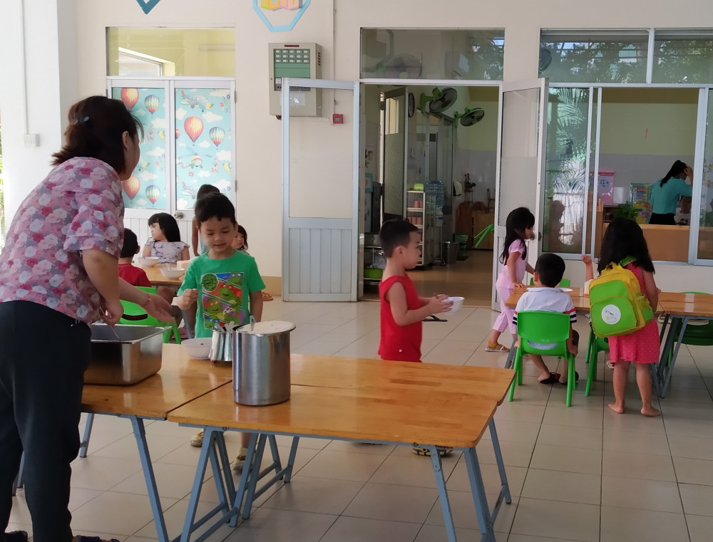 Nhân viên trường Mầm non Bé Ngoan (quận 1) đang cho các bé ăn 