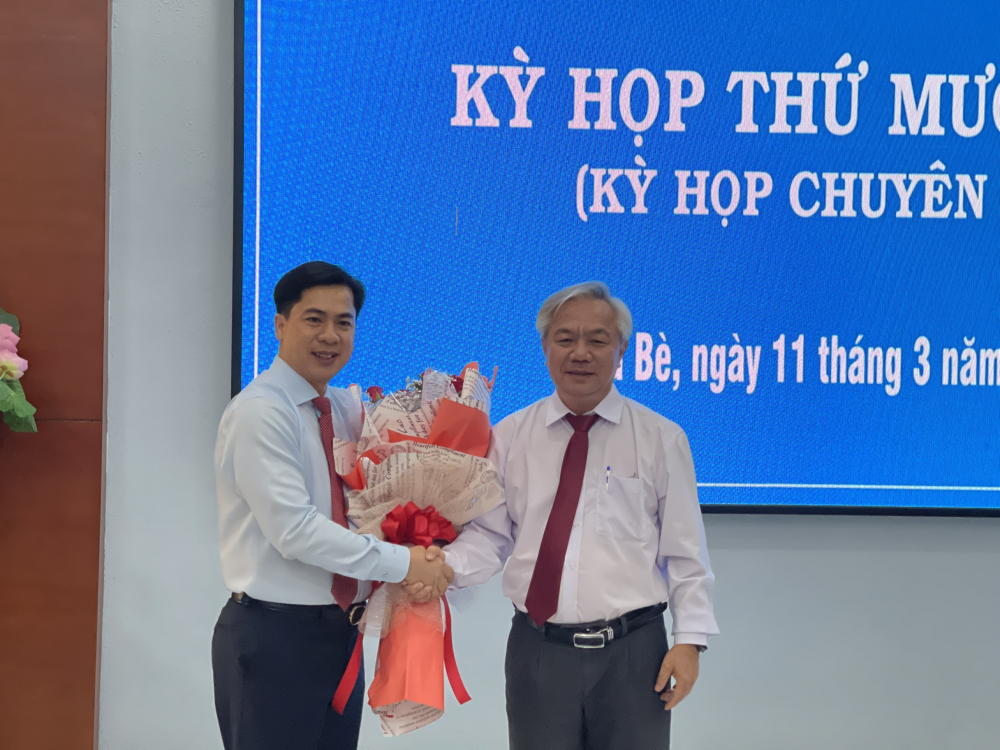 Bí thư Huyện ủy Nhà Bè Dương Thế Trung chúc mừng tân Chủ tịch UBND huyện Nhà Bè Triệu Đỗ Hồng Phước.