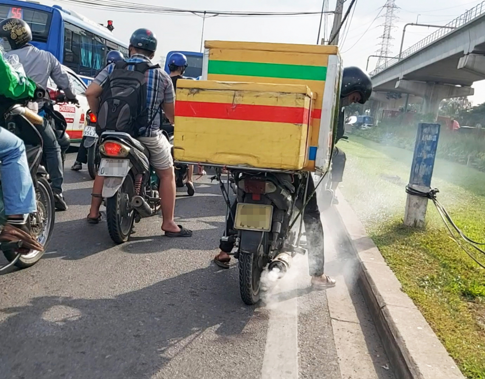 Một chiếc xe máy cũ chở hàng cồng kềnh, xả khói mù mịt chạy từ hướng TP.Thủ Đức về trung tâm TP.HCM