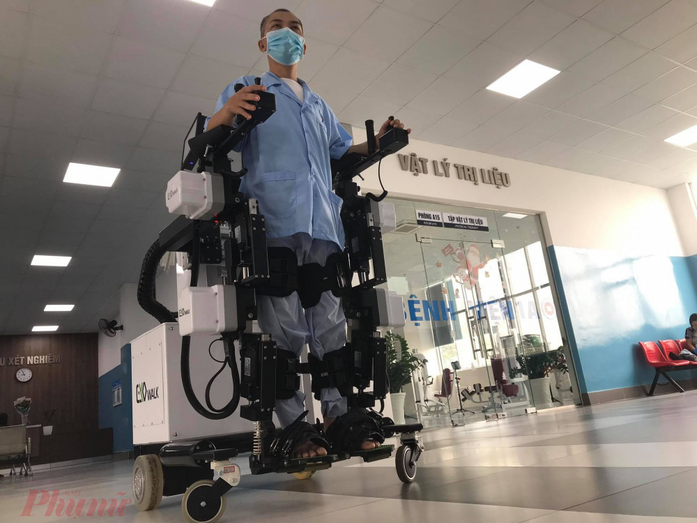 Anh Khang có thể tự bước đi với robot mà không phải ngồi xe lăn.