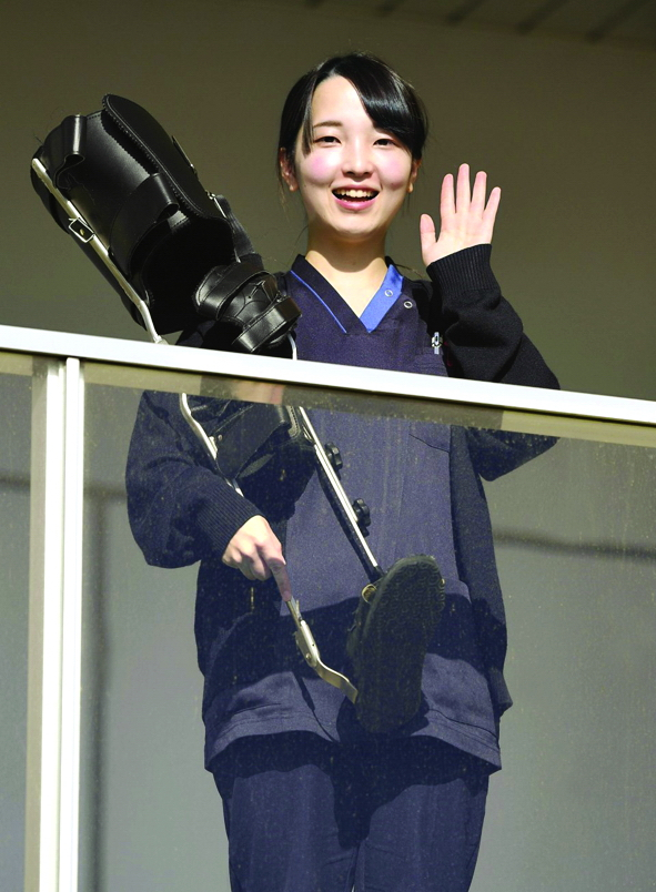 Cô bé Minori Sato cầm bức ảnh của người anh trai quá cố Takanori trong lễ tưởng niệm ngày 28/4/2011 và hình ảnh hiện tại, khi cô bé nhút nhát đã trở thành một nhà vật lý trị liệu Ảnh: Kyodo