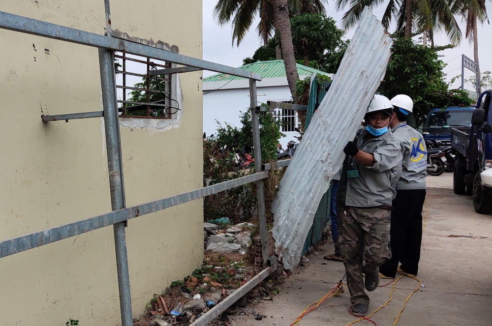 Công nhân tháo dỡ hàng rào của dự án Nha Trang Sao. Ảnh: Trường Nguyên