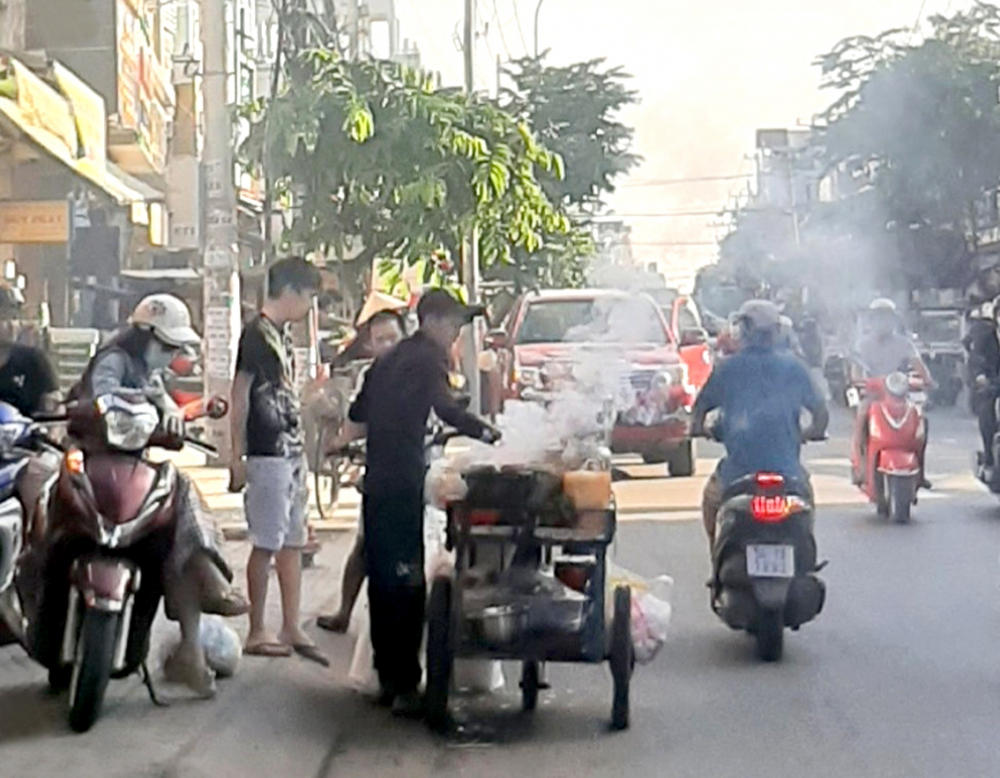 Người bán hàng ăn di động gây khói mù mịt trên đường Nguyễn Ảnh Thủ (Q.12), ảnh chụp sáng 4/4 - Ảnh: hoài An