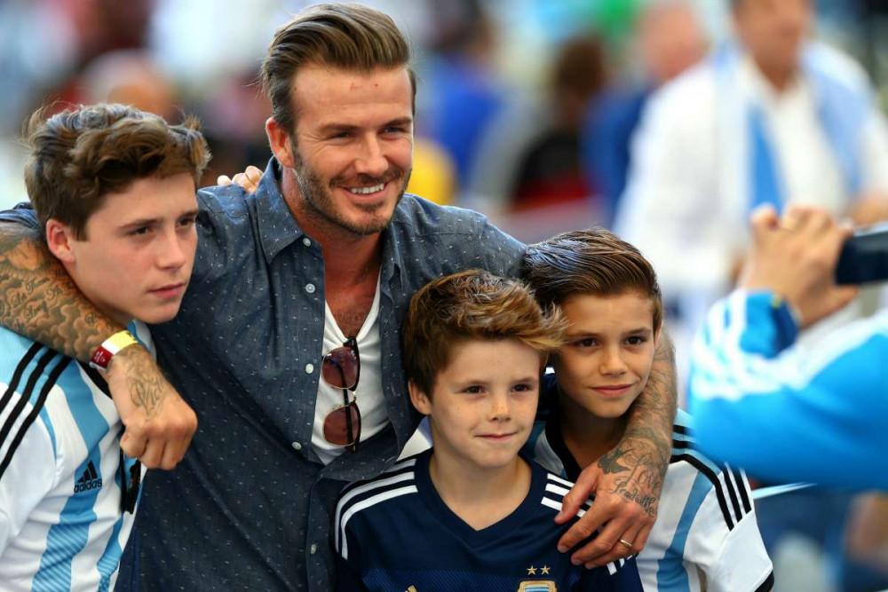 David Beckham bên cạnh các con tại sân cỏ. 