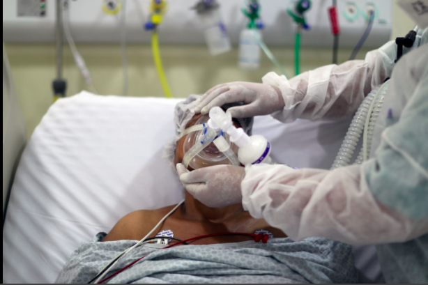 Một nhà vật lý trị liệu điều chỉnh mặt nạ dưỡng khí trên một bệnh nhân mắc bệnh coronavirus (COVID-19) tại ICU của Bệnh viện Thành phố Parelheiros ở Sao Paulo, Brazil ngày 8 tháng 4 năm 2021. REUTERS / Amanda Perobelli / File Photo