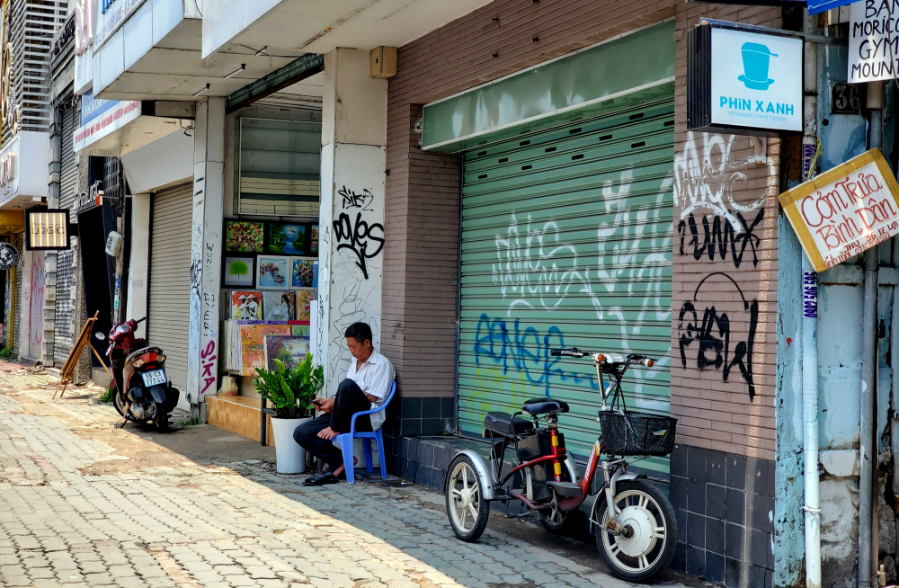 Thì đường Lê Lợi lúc nào cũng vắng vẻ, nhiều cửa hàng buộc phải đóng cửa dài hạn, trở thành nơi dừng chân nghỉ ngơi của người bán dạo. 