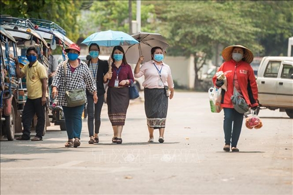 Người dân Lào đeo khẩu trang phòng, chống dịch COVID-19 - Ảnh: TTXVN