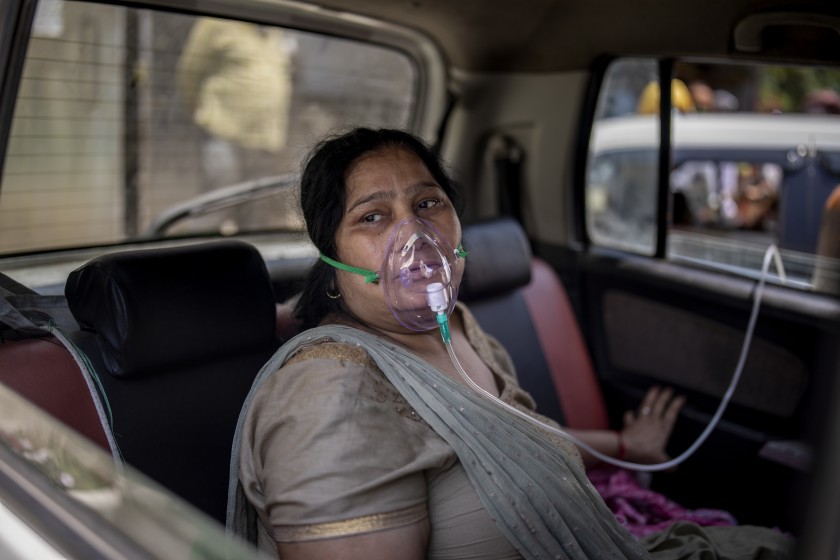 Một bệnh nhân COVID-19 thở oxy bên ngoài một bệnh viện ở Delhi, Ấn Độ
