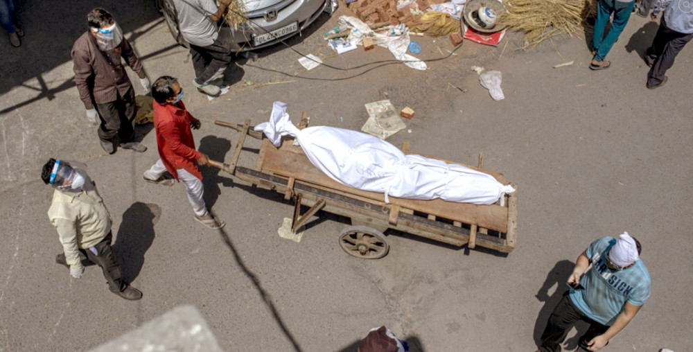 Một thi thể đang được đưa đến bãi đất được dùng làm nơi hỏa táng người chết do COVID-19 ở New Delhi, Ấn Độ - Ảnh: AP