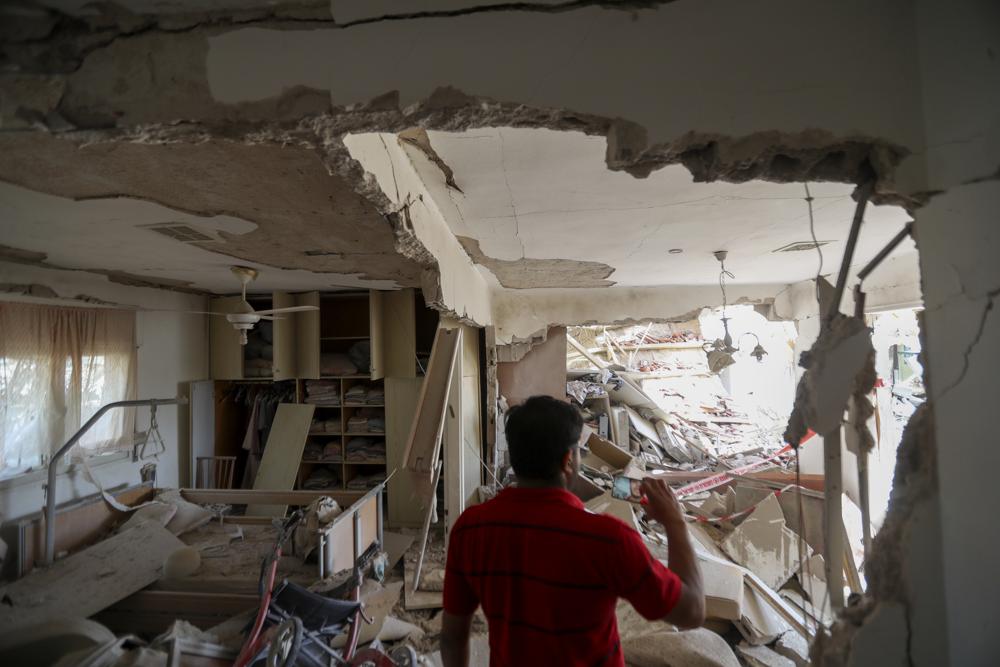 Một người đàn ông kiểm tra ngôi nhà bị hư hại nặng nề sau khi nó bị trúng tên lửa từ Dải Gaza, ở thành phố Ashkelon, miền nam Israel 