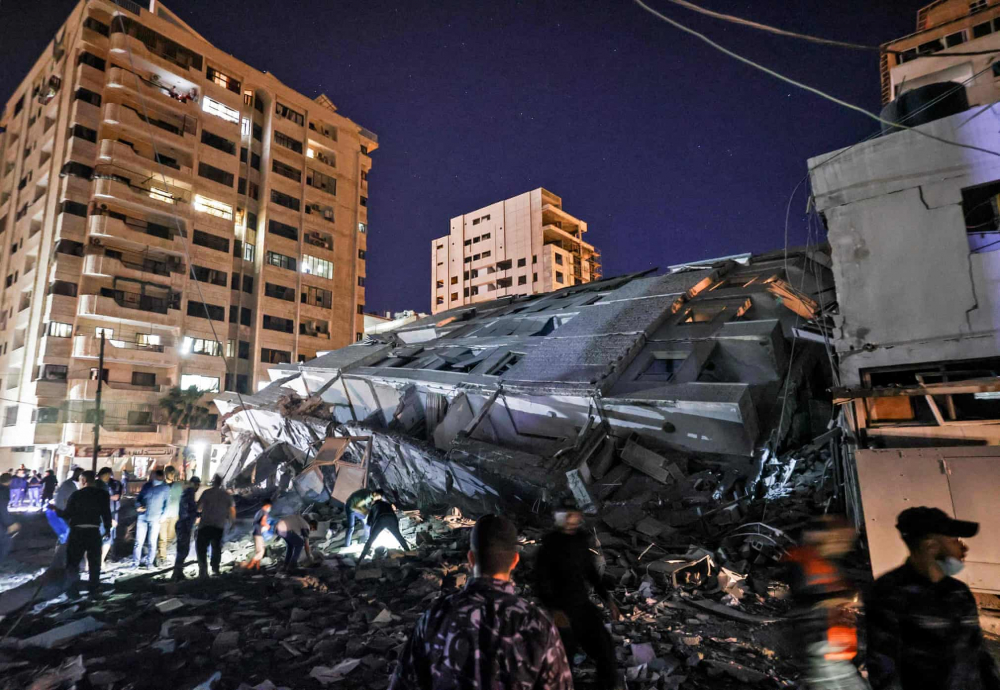 Người dân tập trung tại một tòa nhà bị sập sau cuộc không kích của Israel vào thành phố Gaza