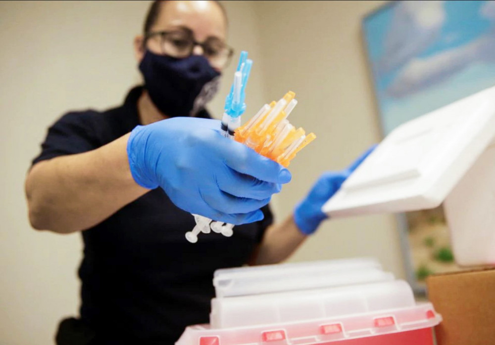 Một nhân viên y tế chuẩn bị ống tiêm chứa vắc-xin Moderna và Pfizer tại một trung tâm  tiêm chủng ở El Paso, Texas - Ảnh: Reuters
