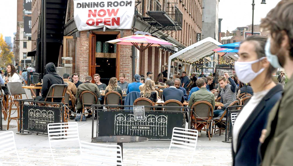 Nhiều người ăn uống cùng nhau ngoài trời tại một nhà hàng trên đường phố New York, khi cuộc sống bắt đầu quay lại bình thường - Ảnh: Getty Images