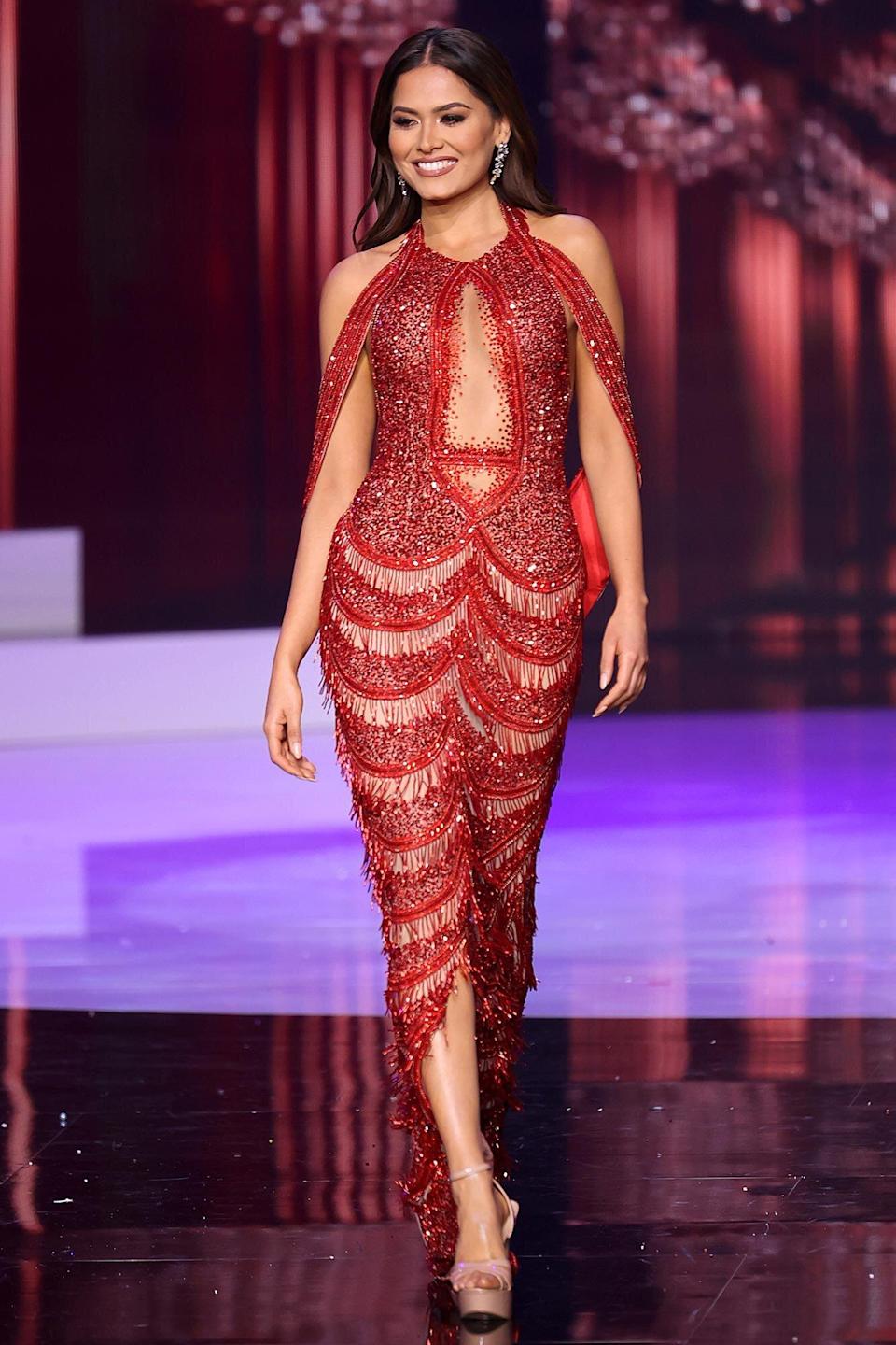 Trong vòng thi trang phục dạ hội, Andrea Meza lựa chọn thiết kế màu đỏ bắt mắt, phom ôm sát để phô diễn đường cong cơ thể. 