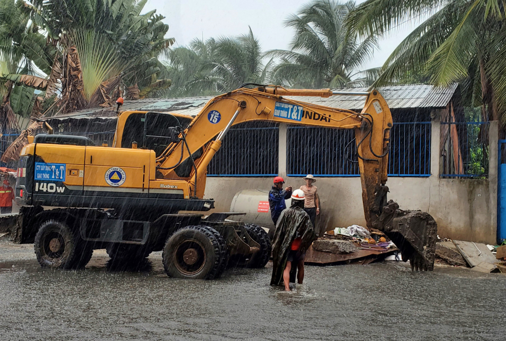 Sau đó, một xe máy xúc được đưa đến, phá dở miệng cống thì tình trạng ngập mới được giảm bớt khi trời đang mưa to