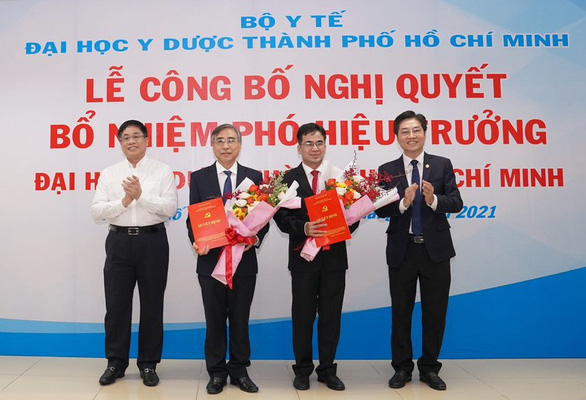 Lãnh đạo nhà trường trao nghị quyết và hoa chúc mừng cho TS Hà Mạnh Tuấn (thứ 2 từ trái) và PGS.TS Ngô Quốc Đạt (thứ 3 từ trái)