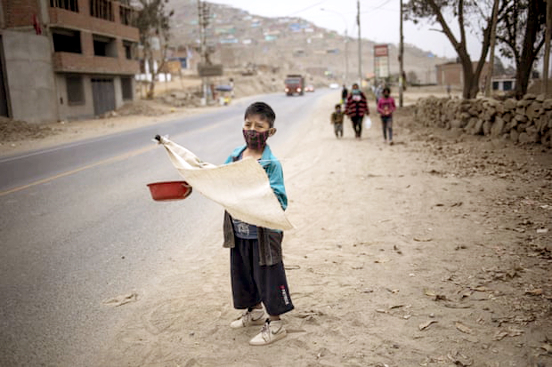 Một cậu bé bảy tuổi ăn xin ở ngoại ô Lima, Peru giữa đại dịch COVID-19 - Ảnh: AP