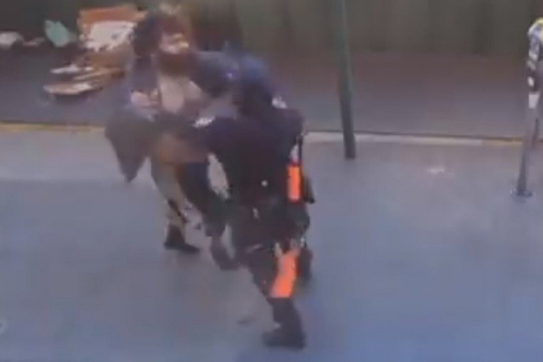 Ảnh được chụp từ video cho thấy người đàn ông vô gia cư đã tấn công nữ cảnh sát, dù sau đó có bốn người đàn ông khác vào can thiệp nhưng anh ta vẫn không buông ra