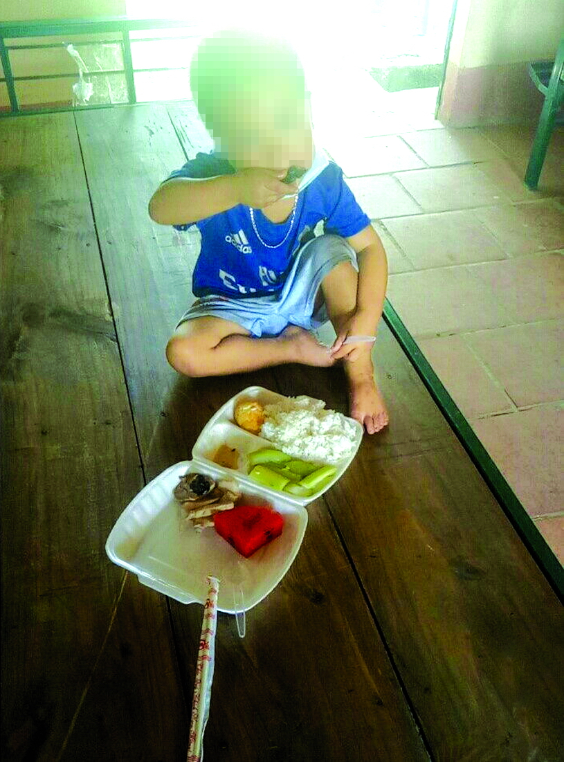 Bé M. (ba tuổi) tự ăn cơm một mình trong khu cách ly