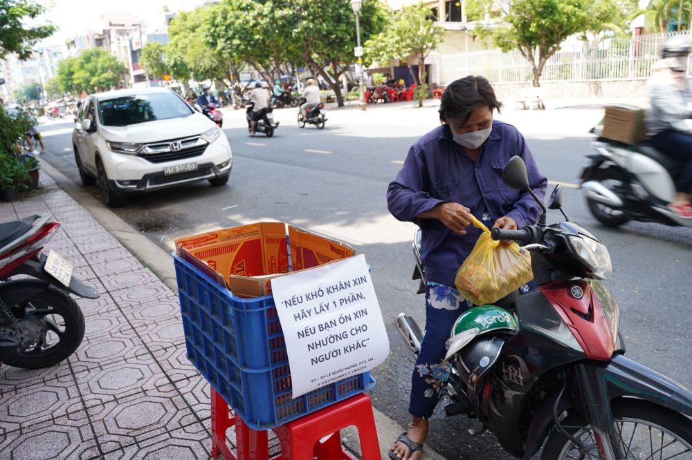 Một người dân nhận mì và trứng trước điểm phát hàng miễn phí