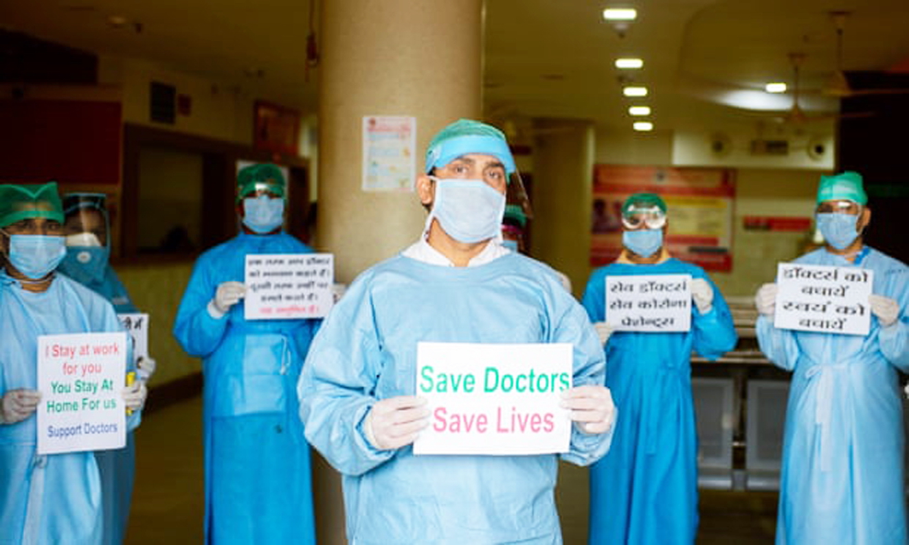 Nhân viên y tế tại Bệnh viện Narayan Swaroop ở Allahabad, Ấn Độ,  cầm biểu ngữ phản đối hành hung, bạo lực - Ảnh: AFP