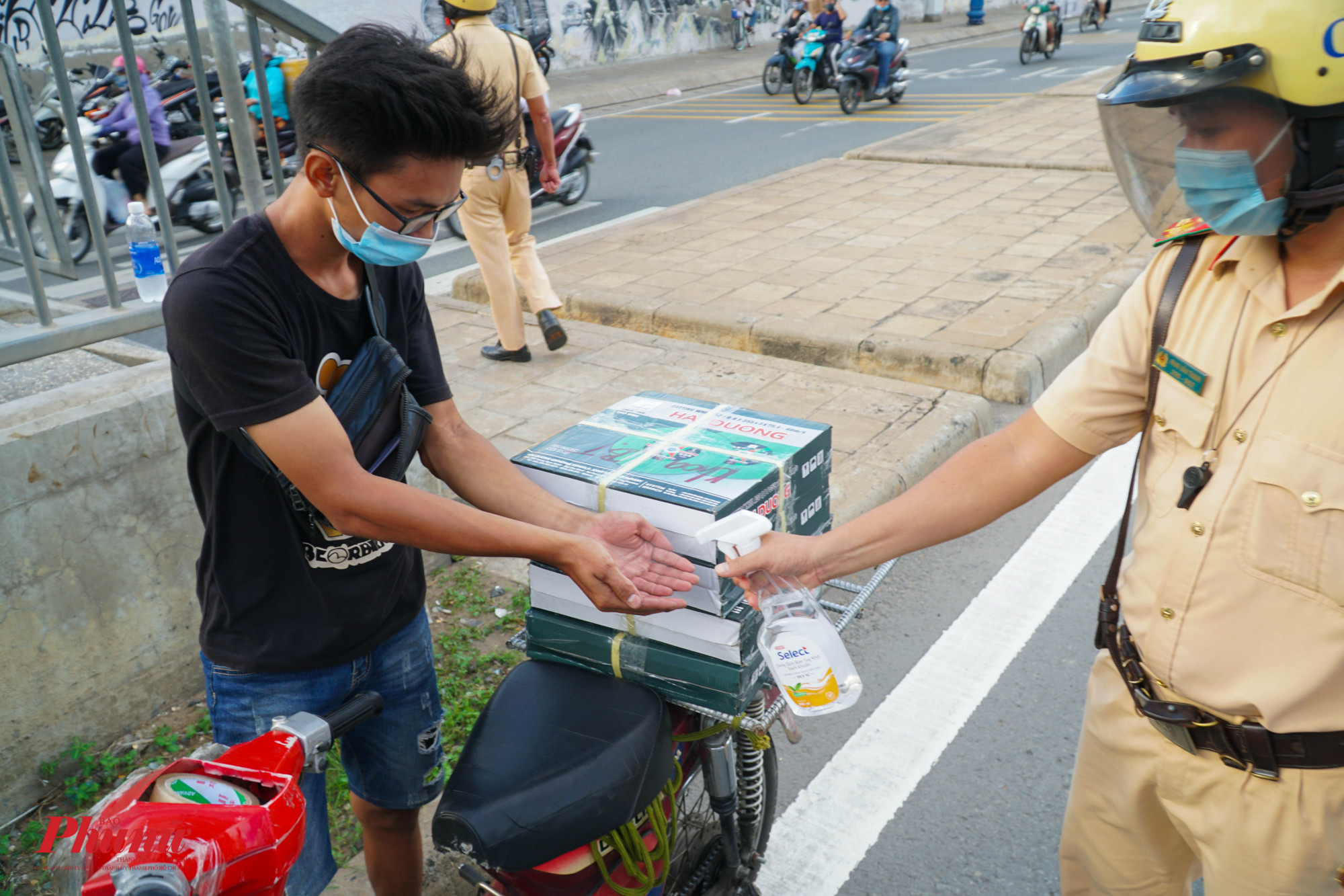 Trước khi làm việc, lượt lượng CSGT tiến hành xịt khử khuẩn tay cho người đièu khiển phương tiện