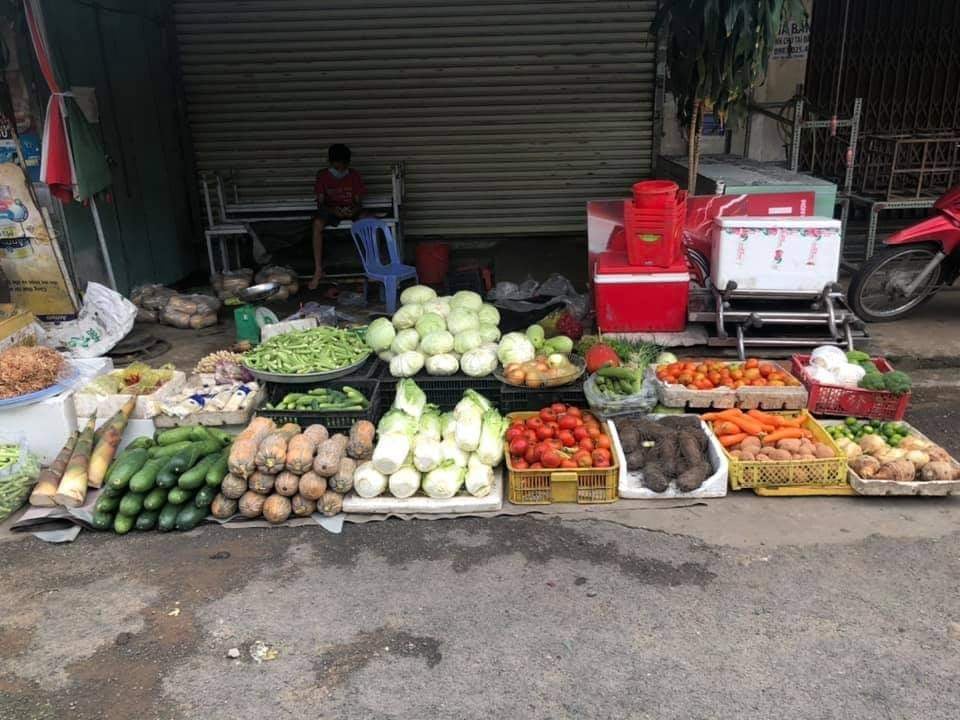 Một gian hàng bán rau củ trong chợ được bày ra nhưng không có người mua