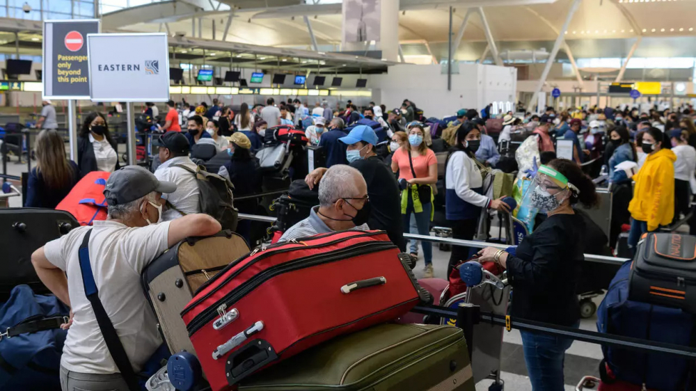 Hành khách xếp hàng làm thủ tục tại Sân bay John F. Kennedy ở New York ngày 28/5/2021 khi việc đi lại được nới lỏng - Ảnh: AFP
