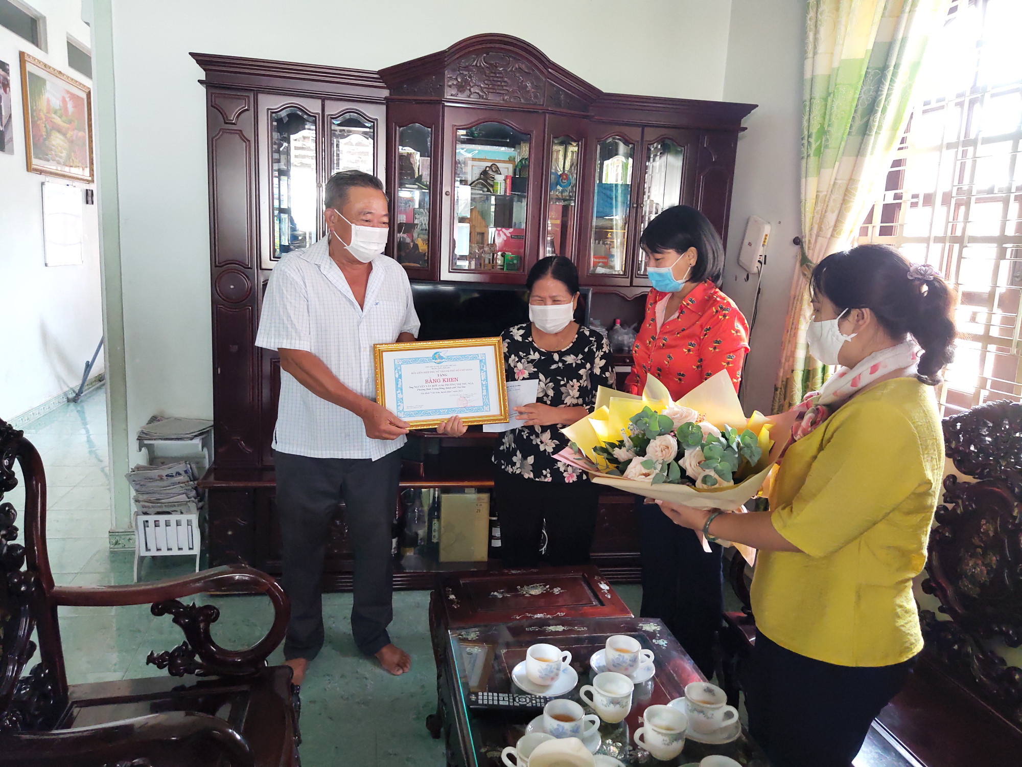 Bà Trần Thị Phương Hoa - PHó Chủ tịch Hội LHPN TP trao bằng khen và hoa tuyên dương gia đình hạnh phúc cho gia đình bà Trương Thị Thu Nga