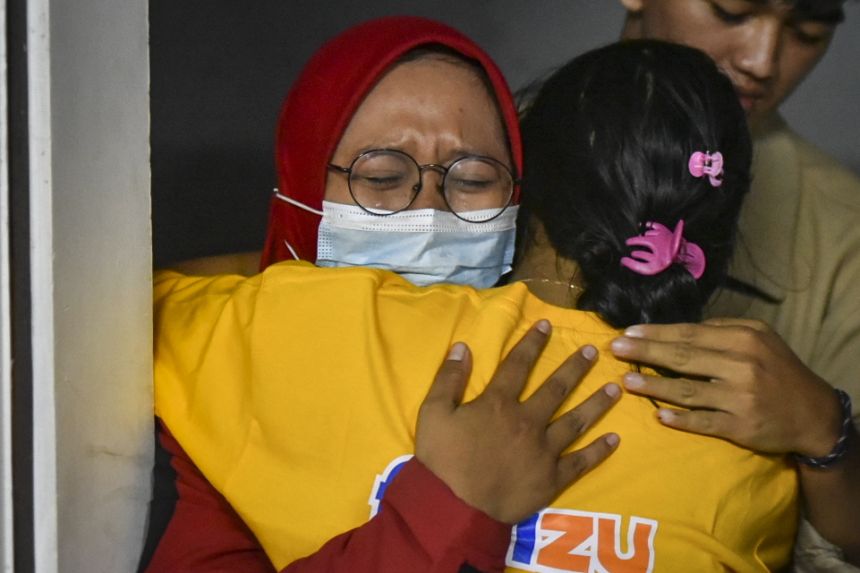 Hành khách ôm nhau khi đến một cảng ở Banyuwangi, Đông Java, sau vụ tai nạn ở cảng Gilimanuk của Bali
