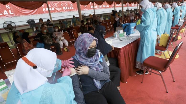 Hàng nghìn người Indonesia xếp hàng tại một sân vận động thể thao để được tiêm một liều vắc-xin COVID-19 vào ngày đầu tháng Bảy