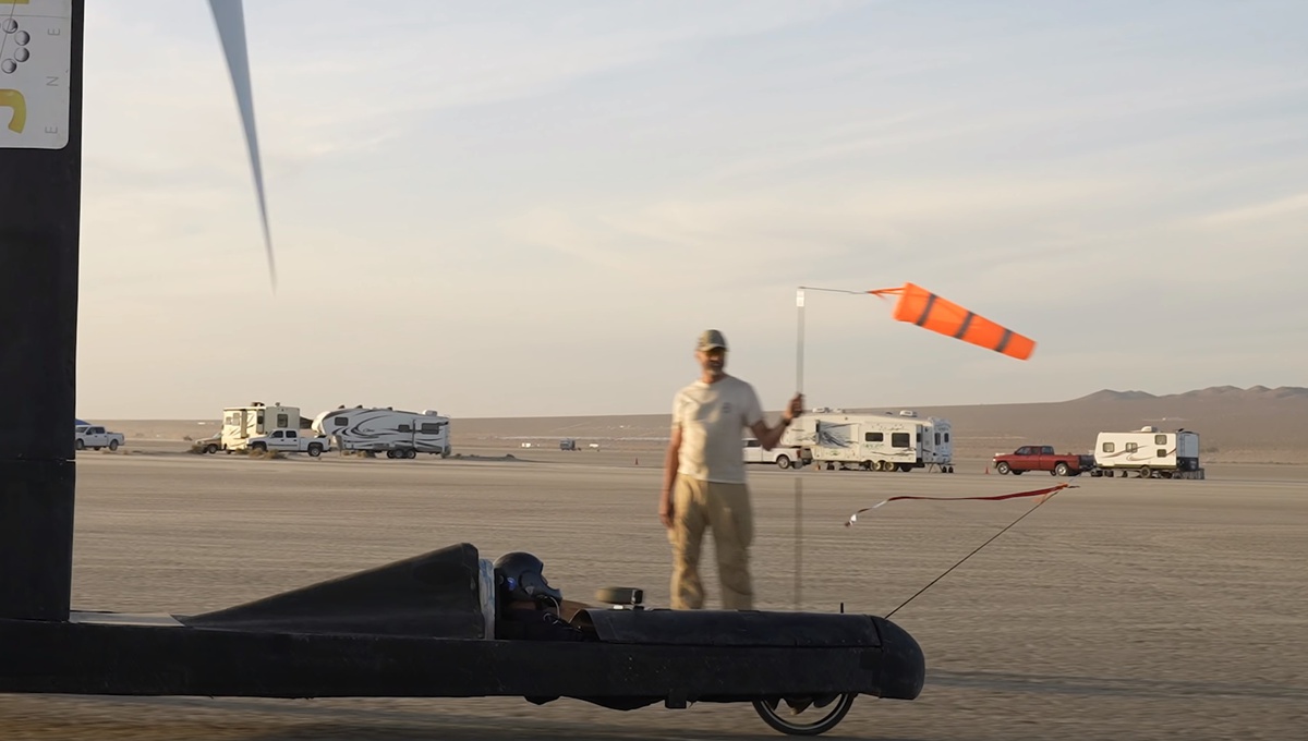 Bức ảnh cho thấy hướng gió thổi về bên phải (người cầm cờ), nhưng lá cờ ở mũi xe lại bay về phía trái, cho thấy tốc độ của xe lớn hơn gió