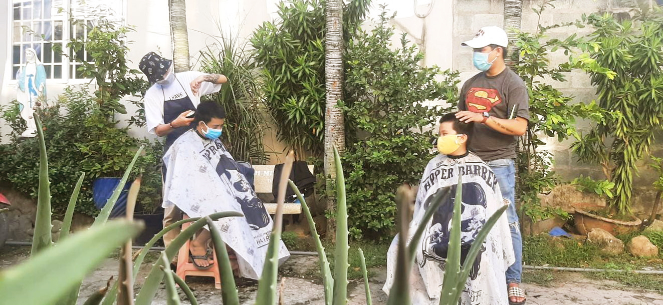 Thợ hớt tóc cho khách tại nhà ở một con hẻm tại xã Bà Điểm, H.Hóc Môn, TP.HCM   