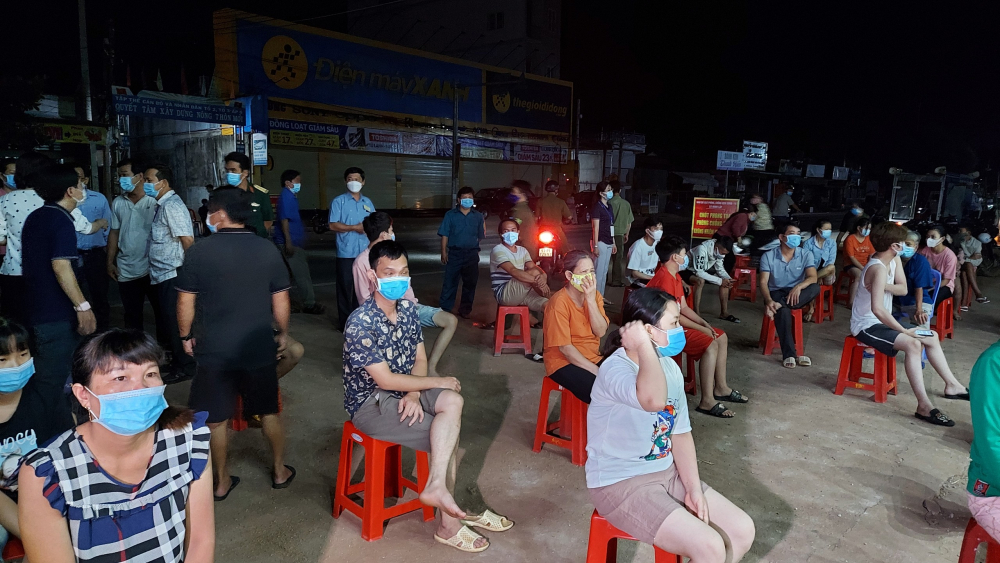 Người dân tập trung tại khu vực Cửa hàng Bách Hóa Xanh, xã Minh Lập, huyện Chơn Thành để chờ lấy mẫu xét nghiệm