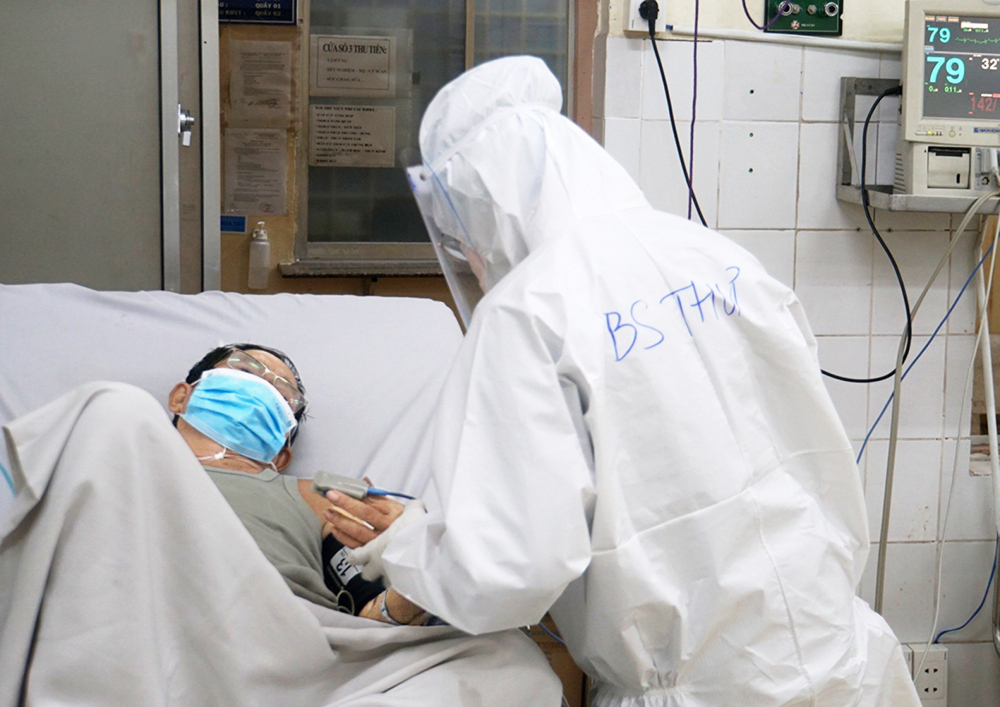 Y, bác sĩ Khoa Cấp cứu, Bệnh viện Điều trị COVID-19 Trưng Vương thăm khám bệnh nhân COVID-19 nặng - Ảnh: Phạm An