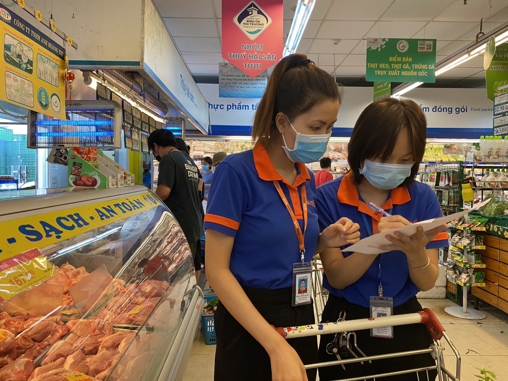 Nhân  viên siêu thị đang đi  chợ  thay cho  khách  hàng  tại  siêu  thị Co.op  Nhiêu  Lọc  trong sáng đầu tiên  thực  hiện giãn các xã hội tại TPHCM. Ảnh: Quốc  Thái