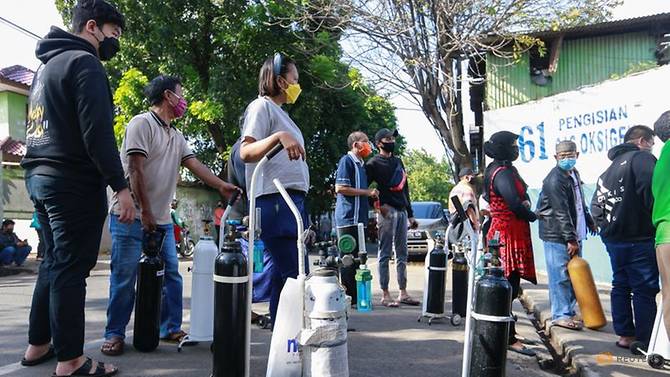 Người dân xếp hàng chờ đợi để nạp bình oxy bên ngoài nhà máy ở ở Jakarta, Indonesia, 