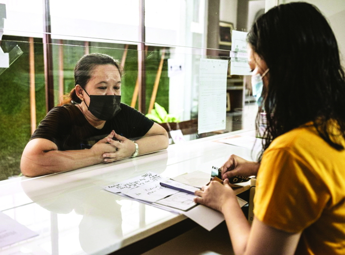 Một nhân viên tuyển dụng của ABD Overseas Manpower Corp. ở Makati, Philippines hỗ trợ chị Juvy Magno hoàn thiện hồ sơ xin việc làm giúp việc gia đình ở Ả Rập Saudi