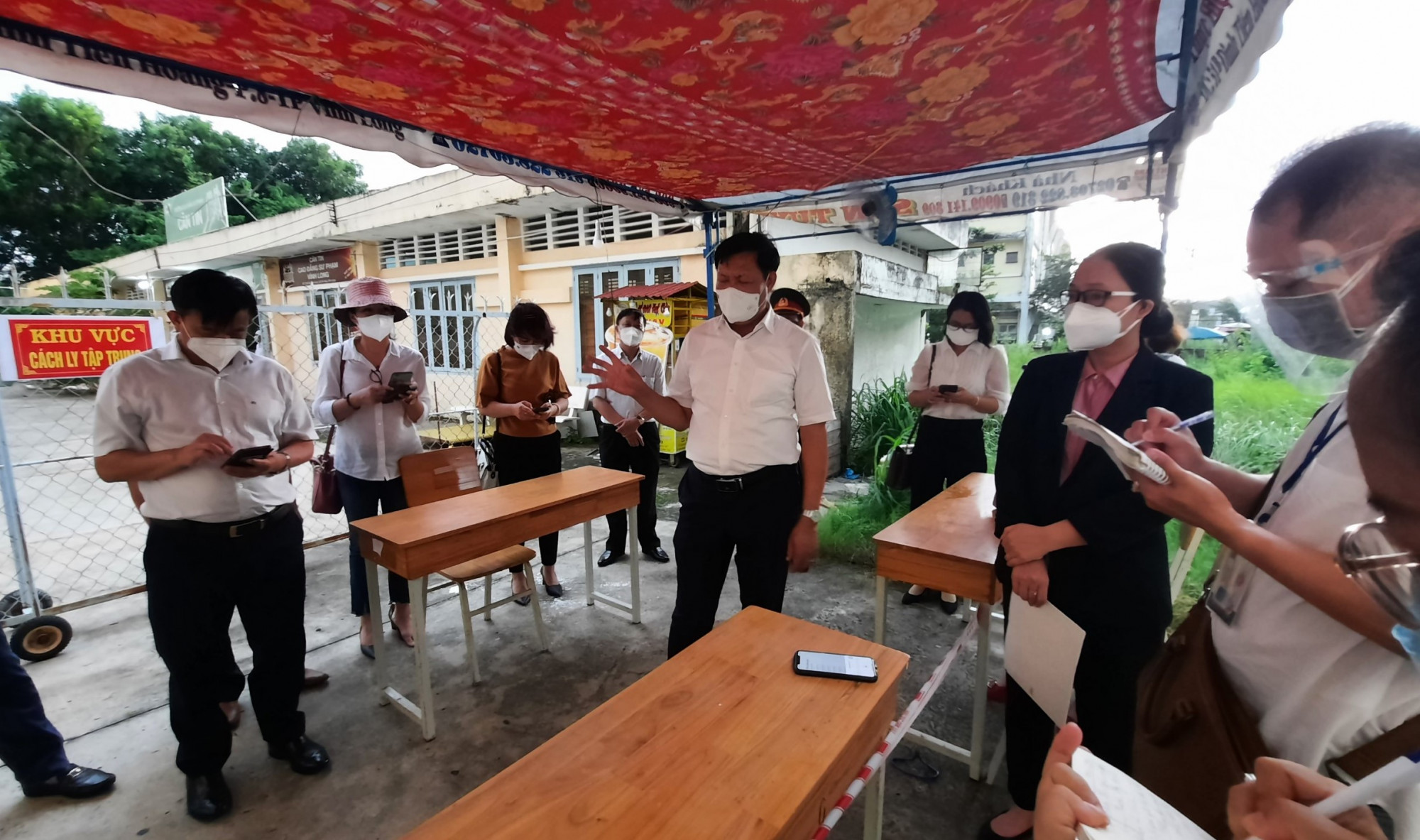 Thứ trưởng Bộ Y tế (người đứng giữa) trực tiếp hướng dẫn quy trình kiểm soát dịch ở vùng phong tỏa ở Vĩnh Long