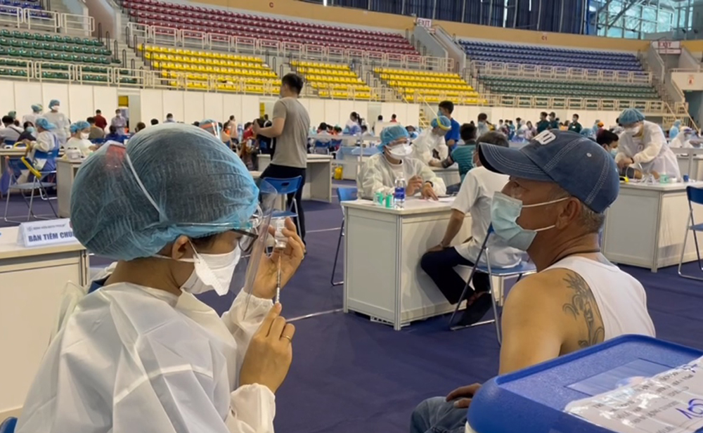 Nhân viên y tế tiêm vắc xin ngừa COVID-19 cho người dân tại Nhà thi đấu Phú Thọ
