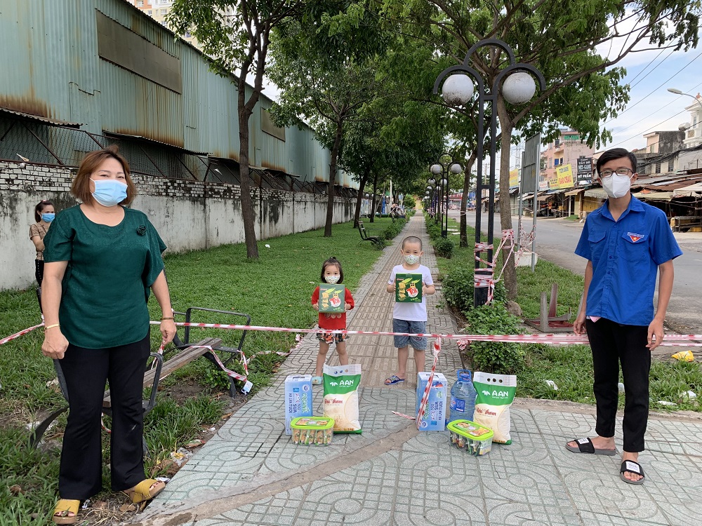 Đại diện Mặt trận Tổ quốc Việt Nam TPHCM trao tặng sữa Cô Gái Hà Lan cho các bé tại các khu vực bị phong toả do có ca nhiễm trên địa bàn quận 12, quận 7 và nhiều quận huyện khác - Ảnh: CGHL