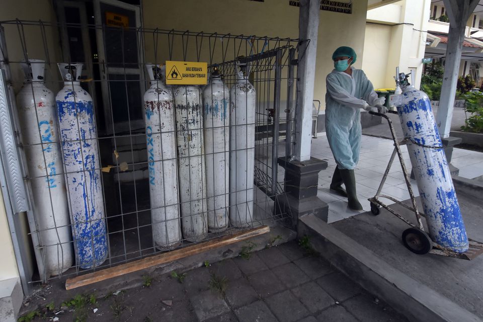 Một nhân viên y tế kéo một bình oxy để được chuyển đến khu cấp cứu tại một bệnh viện do chính phủ điều hành trong bối cảnh dịch bệnh bùng phát ở Denpasar, Bali