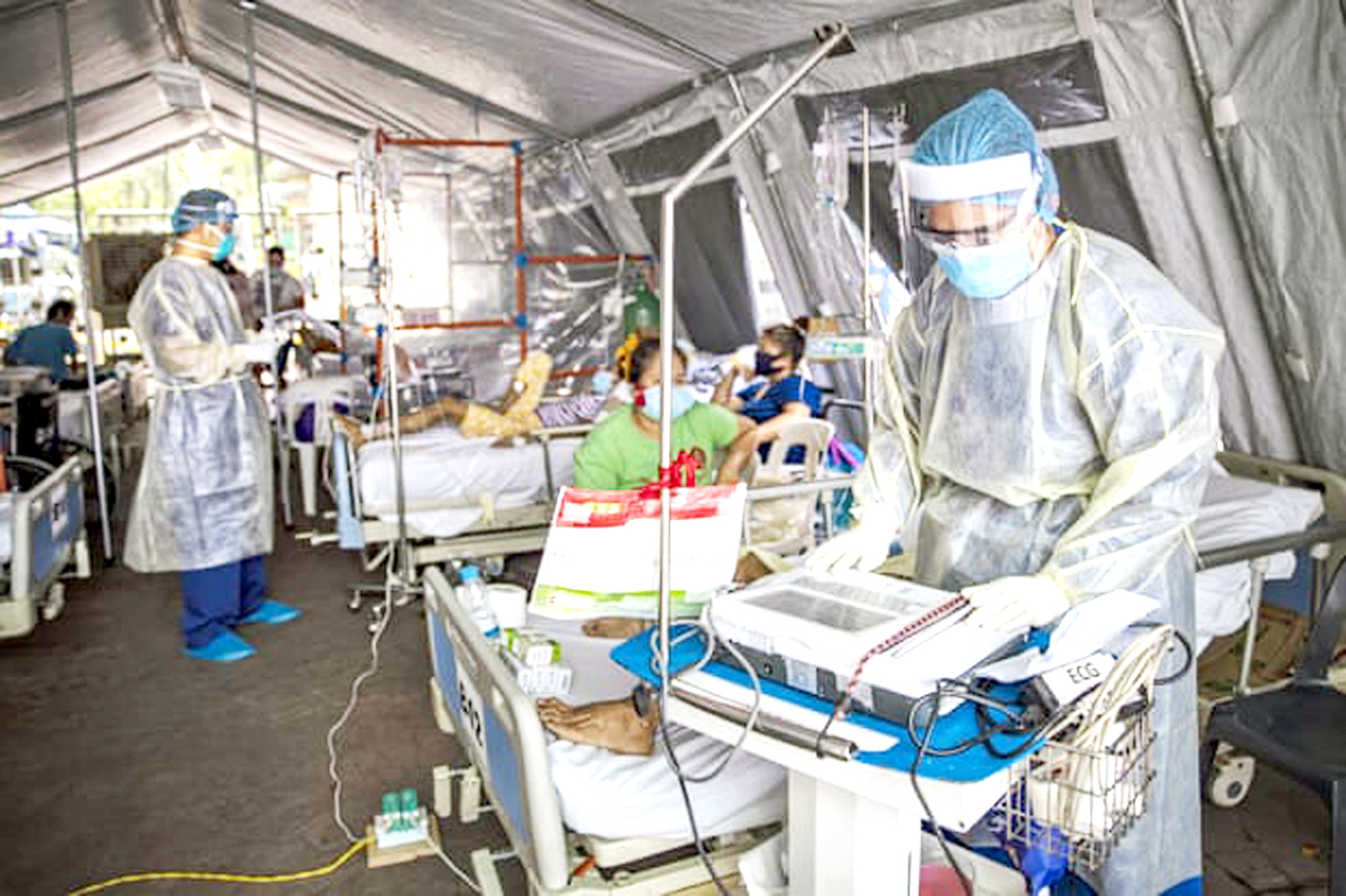 Nhân viên y tế điều trị bệnh nhân COVID-19 trong lều tại cơ sở cách ly tạm thời ở Manila, Philippines - ẢNH: AP 