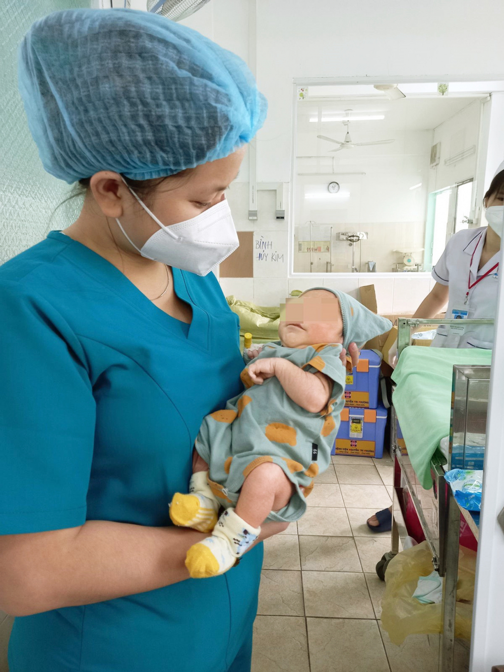 Y, bác sĩ Khoa Nhi, Bệnh viện Nguyễn Tri Phương chăm sóc cho một trẻ sơ sinh có mẹ  mắc COVID-19 - Ảnh do bệnh viện cung cấp