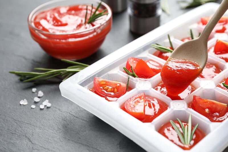 Xay nhuyễn cà chua, cho vào khay đá, đặt vào tủ lạnh. Hoặc bạn cũng có thể nhúng sơ cà chua tươi qua nước nóng, lột bỏ vỏ, cắt đôi trái, bảo quản trong ngăn đông.