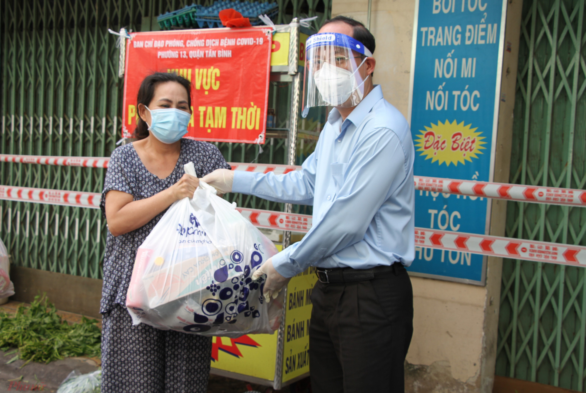 Phó bí thư Thành ủy TPHCM Nguyễn Hồ Hải trao quà động viên lực lượng trực chốt, và người dân có hoàn cảnh khó khăn bên trong khu phong tỏa hẻm 56, đường Văn Chung, phường 13, quận Tân Bình